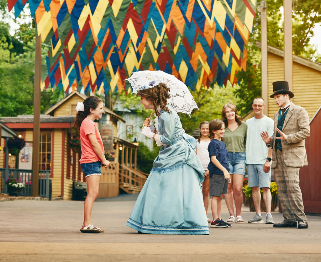 Costumed street characters greeting families under festival banners — Silver Dollar City in Branson, Missouri