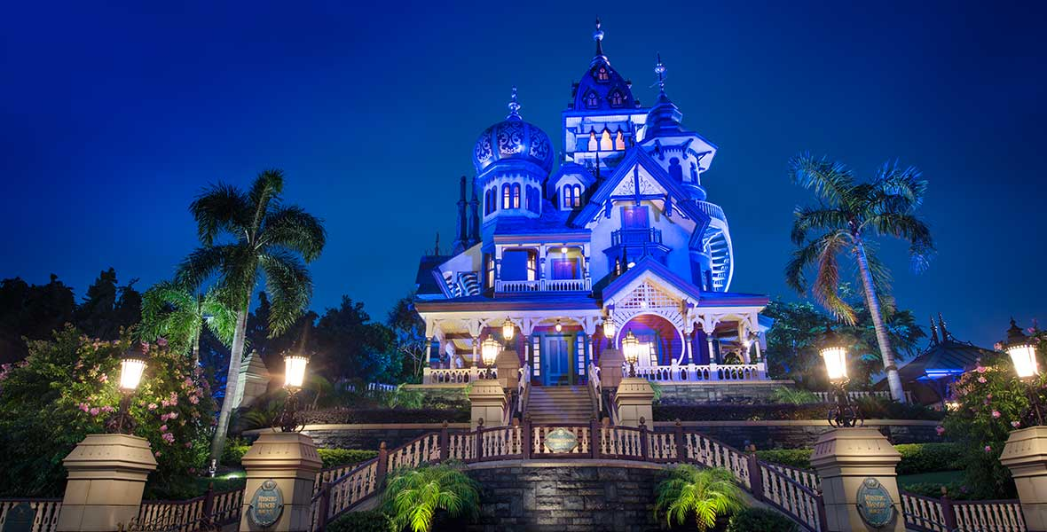 Mystic Manor glowing blue at night in Mystic Point — Hong Kong Disneyland in Lantau Island, Hong Kong