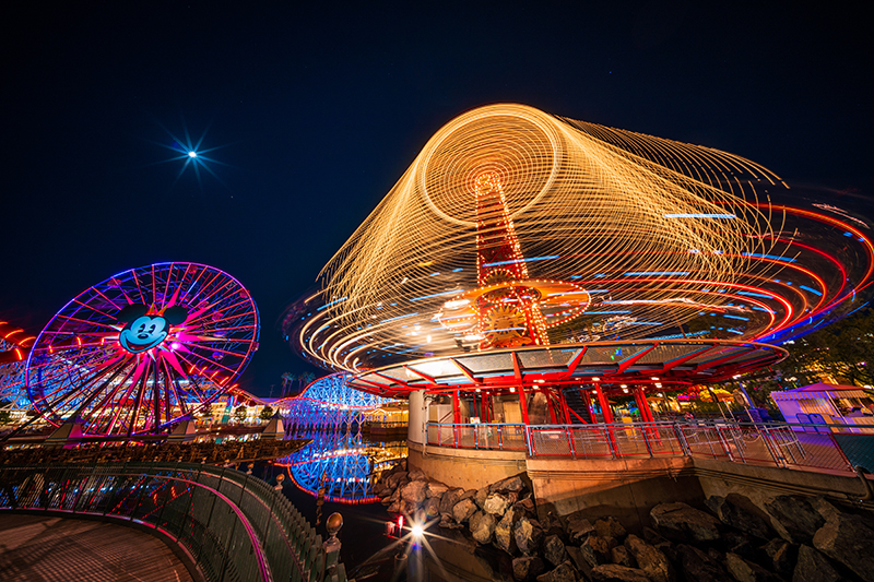 Silly Symphony Swings spinning in light trails beside Pixar Pier at night — Disney California Adventure in Anaheim, California