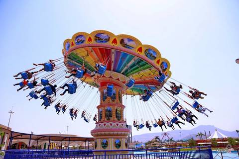 Riders Soaring on a Colorful Wave Swinger — Six Flags Magic Mountain in Valencia, California